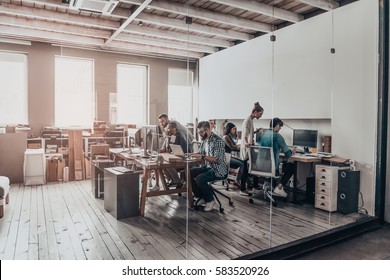 Geschäftsteam.  Gruppe junger Unternehmer, die zusammen arbeiten und kommunizieren, während sie an ihren Arbeitsplätzen im Büro sitzen 
