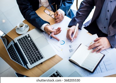 Business team hands at working with plan on office desk and modern digital computer laptop. Top view shot. - Shutterstock ID 368205530