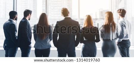 Business team having break at meeting, looking through window, back view