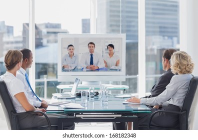 Business Team Having Video Conference With Another Business Team In Office