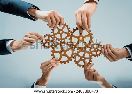 Business team joining cogwheel in circular together symbolize successful group of business partnership and strong collective teamwork unity in workplace community with productive efficiency. Shrewd