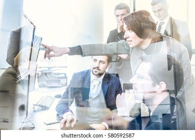 Business Team Looking At Data On Multiple Computer Screens In Corporate Office. Businesswoman Pointing On Screen. Business People Trading Online. Business, Entrepreneurship And Team Work Concept.