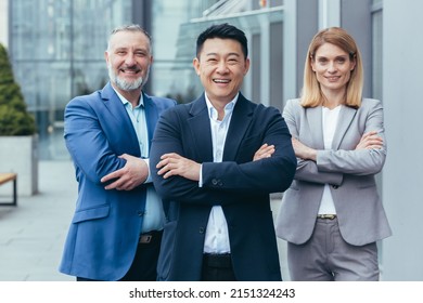 Business team, male and female colleagues in business attire looking at camera and smiling with arms crossed - Shutterstock ID 2151324243