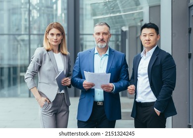 Business team, male and female colleagues in business clothes near the office are looking at the camera serious and confident business people - Shutterstock ID 2151324245