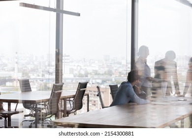 Business team meeting in contemporary business center, talking at office conference table, negotiating on project in modern interior with big panoramic window. Through glass view background - Shutterstock ID 2154300881