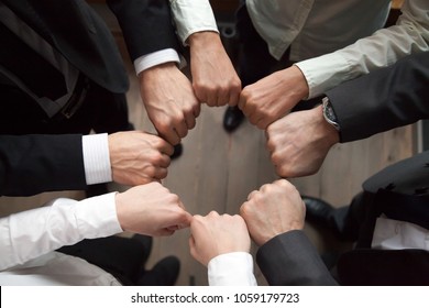 Business Team Or Partners Put Fists In Circle As Concept Of Motivating Engaging Teambuilding Activity, Reliable Support, Help In Cooperation, Trust Unity In Collaboration Teamwork, Close Up Top View