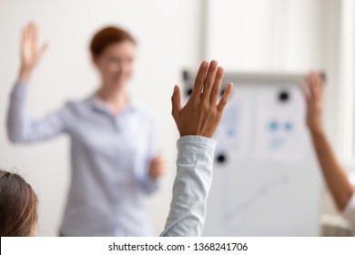 Business team people audience raise hands up ask questions coach engaged in voting at conference concept, volunteers group participate in training presentation corporate seminar, focus on raised hand