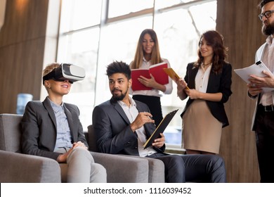 Business team presenting new project to a client on a virtual reality simulator. Focus on the client with VR glasses - Powered by Shutterstock