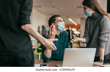 Business Team In Protective Masks Discussing Work Issues.