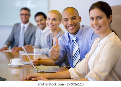 Business Team Sitting In A Line At A Meeting Table.