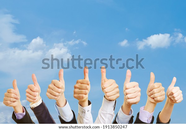 Business team under the\
sky with thumbs up