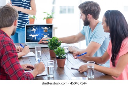 Business team using a laptop against composite image of four drones - Powered by Shutterstock