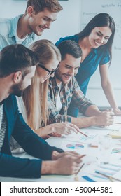 Business Team At Work. Side View Of Five Cheerful Business People In Smart Casual Wear Discussing Something While Looking At The Graphs And Charts