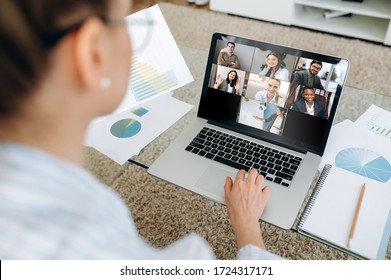 Business team working from home in a video conference. The back view of a girl who communicates online by video conference with her work colleagues using a laptop - Shutterstock ID 1724317171
