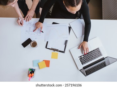 Business Team Working On A New Plan With Laptop. Top View Of Two Young Women Executives Working Together With Laptop And Taking Notes.