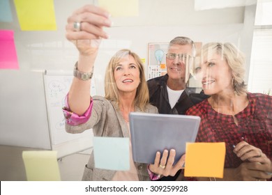 Business Team Working On Tablet And Sticky Post Its At Office