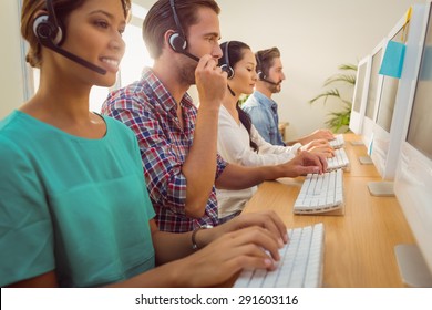 Business Team Working Together At A Call Centre Wearing Headsets