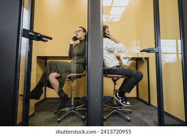 Business teammates having phone call at the same time in different soundproof phone boots at the office.