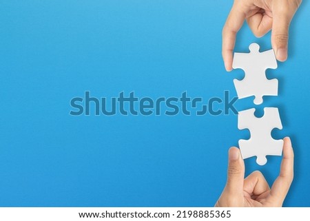 Business teamwork concept. Business solutions, success and strategy. Business people are merging two puzzle pieces.