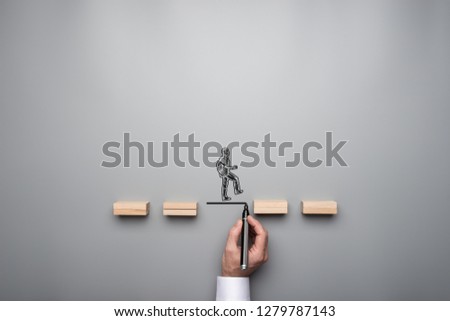 Business teamwork and cooperation concept - silhouette of a businessman walking across wooden pegs with other businessman drawing the missing step for his colleague.