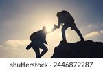 business. teamwork helps hand down business silhouette concept. a group of tourists lend a helping hand, climbing rocks, mountains, lend helping hand. teamwork people climbers climb to travel top