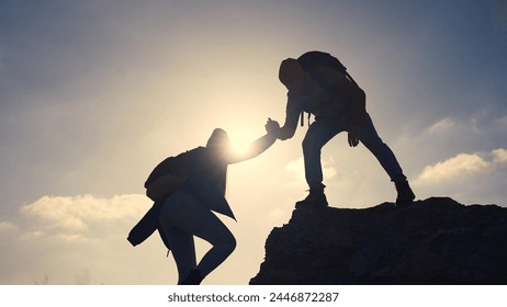 business. teamwork helps hand down business silhouette concept. a group of tourists lend a helping hand, climbing rocks, mountains, lend helping hand. teamwork people climbers climb to travel top - Powered by Shutterstock