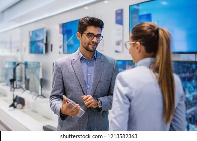 Business At Tech Store. Selling New TV To Customer.