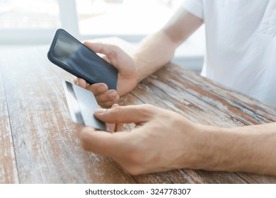 Business, Technology, Cash Free And Internet People Concept - Close Up Of Male Hands Holding Smart Phone And Credit Card On Wooden Table