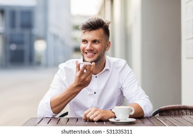 Business, Technology, Communication And People Concept - Young Man With Coffee Using Voice Command Recorder On Smartphone At City Street Cafe