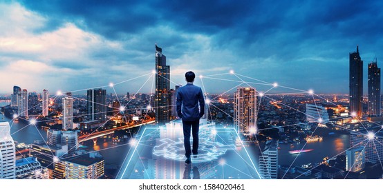 Business technology concept, Professional business man walking on future network city background and futuristic interface graphic at night, Cyberpunk color style - Shutterstock ID 1584020461