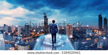 Business technology concept, Professional business man walking on future network city background and futuristic interface graphic at night, Cyberpunk color style