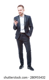 Business And Technology. Full Length Of Confident Young Man In Suit Using Smart Phone. Isolated On White.