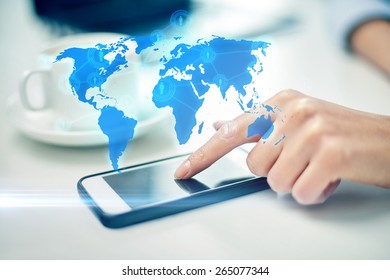 Business, Technology, Global Communication And People Concept - Close Up Of Woman Hand With Smartphone And Coffee Pointing Finger To Screen Over World Map Projection