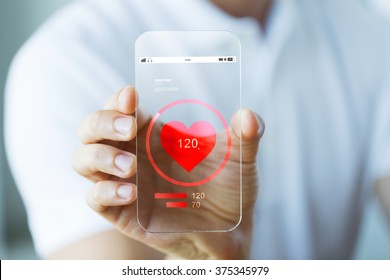 Business, Technology, Health Care And People Concept - Close Up Of Male Hand Holding And Showing Transparent Smartphone With Heart Rate Icon