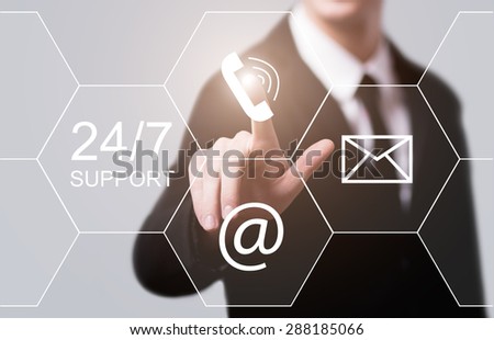 business, technology and internet concept - businessman pressing 24/7 support button on virtual screens
