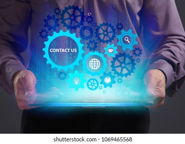 Business, Technology, Internet and network concept. Young businessman working on a virtual screen of the future and sees the inscription: Contact us