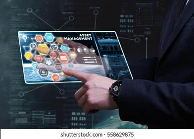 Business, Technology, Internet and network concept. Young businessman working on a tablet of the future, he sees the inscription: asset management 