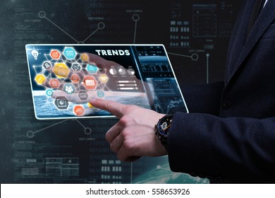 Business, Technology, Internet And Network Concept. Young Businessman Working On A Tablet Of The Future, He Sees The Inscription: Trends 