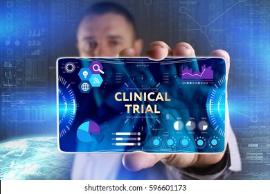 Business, Technology, Internet And Network Concept. Young Businessman Showing A Word In A Virtual Tablet Of The Future: Clinical Trial