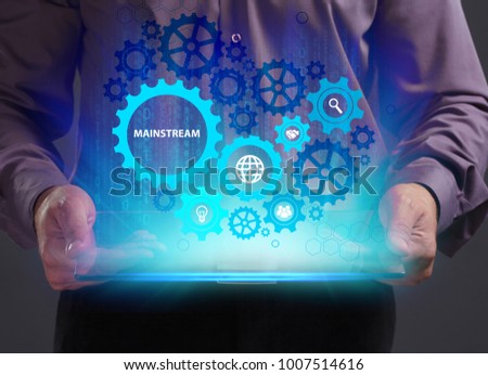 Business, Technology, Internet and network concept. Young businessman working on a virtual screen of the future and sees the inscription: Mainstream