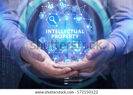 Business, Technology, Internet and network concept. Young businessman shows the word on the virtual display of the future: Intellectual property