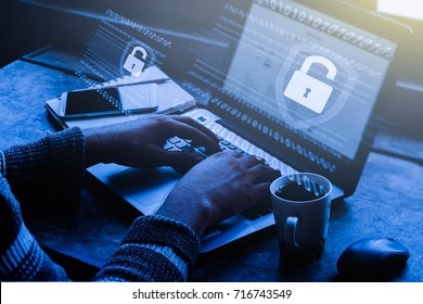 Business, technology, internet and networking concept. Young businessman working on his laptop in the office, select the icon security on the virtual display / Blue tone
