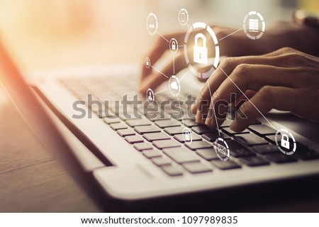 Business, technology, internet and networking concept. Young businesswoman working on his laptop in the office, select the icon security on the virtual display.
