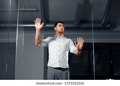 Business, Technology And People Concept - Businessman Working And Touching Glass Wall At Night Office