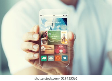 business, technology and people concept - close up of male hand holding and showing transparent smartphone news web page on screen - Powered by Shutterstock