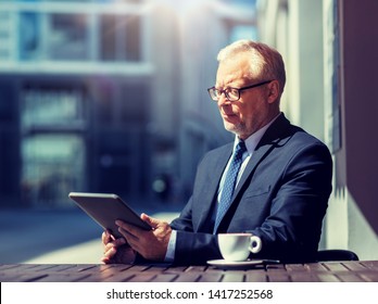 Business, Technology And People Concept - Senior Businessman With Tablet Pc Computer Drinking Coffee At City Street Cafe