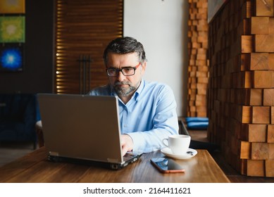 Business, Technology And People Concept , Senior Businessman With Laptop Computer Drinking Coffee At Modern Cafe