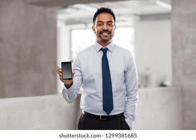 Business, Technology And People Concept - Smiling Indian Businessman With Smartphone Over Office Background