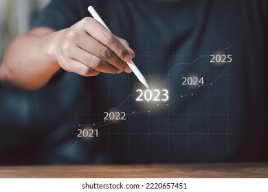 Business and Technology target set goals and achievement in 2023, Businessman planning strategy of rising revenue with digital graphics year 2023 , Businessman using pen touching icon 2023 - Shutterstock ID 2220657451
