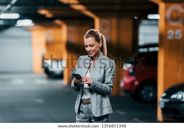 Business, technology and\
transportation concept. Elegant businesswoman using phone in\
underground park\
house.